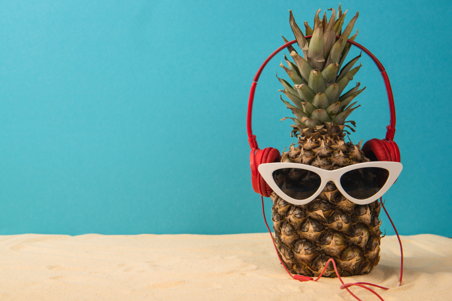 Pineapple with red headphones and white sunglasses